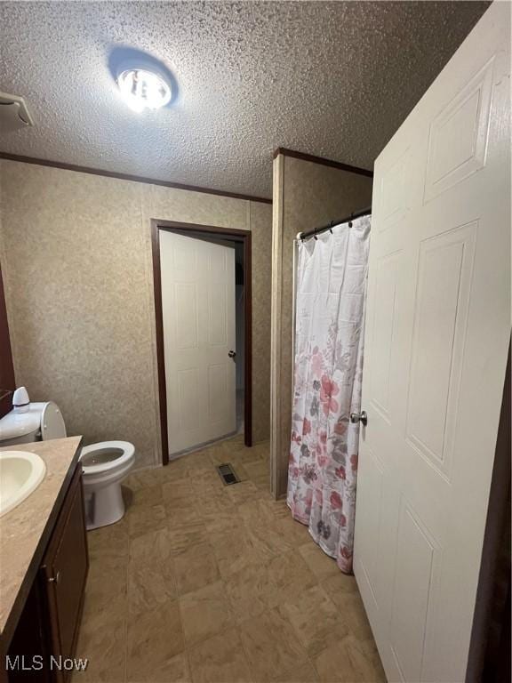 bathroom with walk in shower, toilet, a textured ceiling, ornamental molding, and vanity