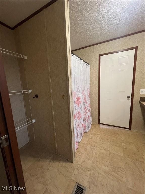 bathroom featuring a textured ceiling and walk in shower