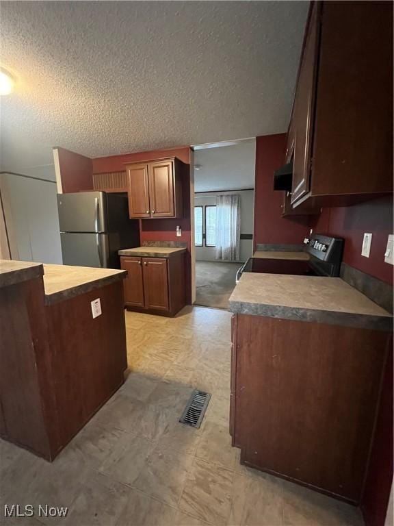 kitchen featuring extractor fan, appliances with stainless steel finishes, and a textured ceiling