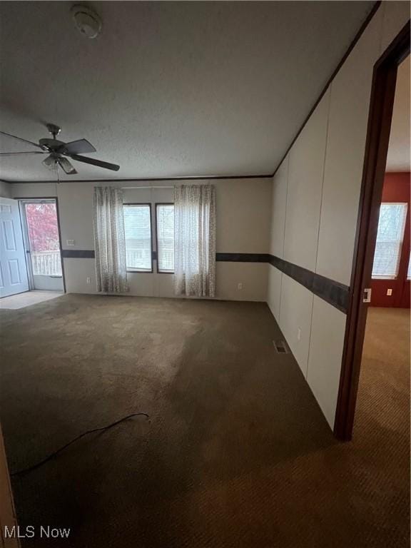 carpeted spare room featuring ceiling fan