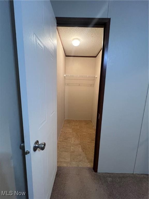 hallway with a textured ceiling