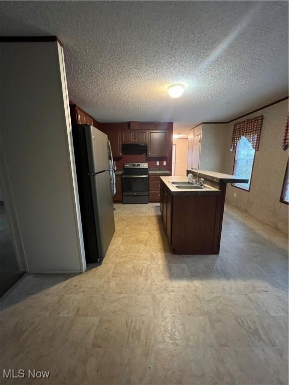 kitchen with sink, dark brown cabinets, stainless steel appliances, a textured ceiling, and a center island with sink