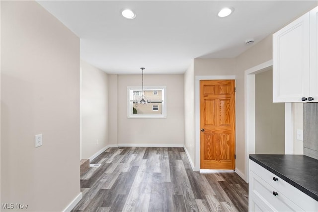 unfurnished dining area featuring dark hardwood / wood-style flooring