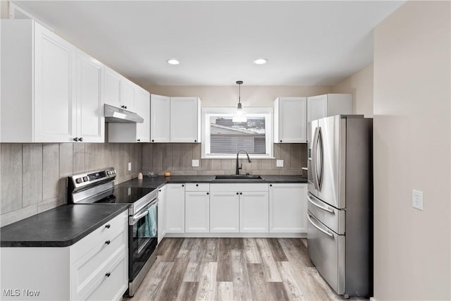 kitchen with sink, appliances with stainless steel finishes, hanging light fixtures, light hardwood / wood-style floors, and white cabinets