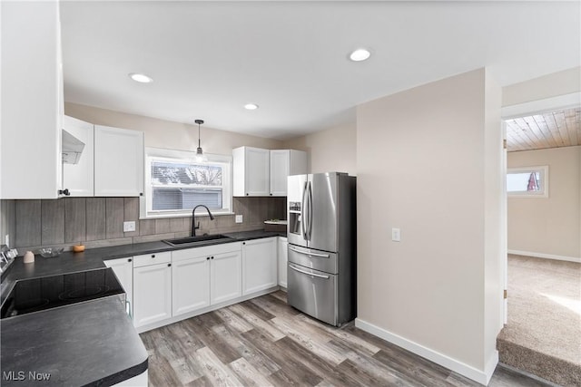 kitchen with sink, tasteful backsplash, appliances with stainless steel finishes, pendant lighting, and white cabinets