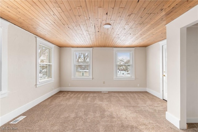 carpeted empty room featuring plenty of natural light and wooden ceiling