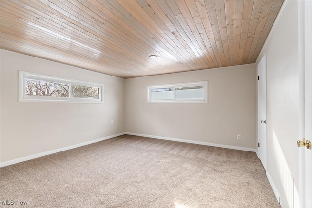 carpeted spare room featuring a wealth of natural light and wooden ceiling