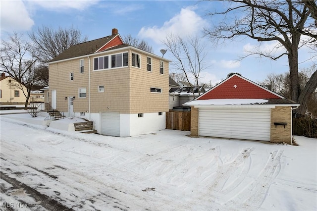 view of snow covered exterior with a garage