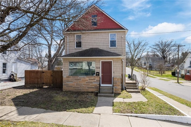 750 Florida Ave, Akron, OH 44314 - view of front of house featuring stone siding, fence, entry steps, and roof with shingles