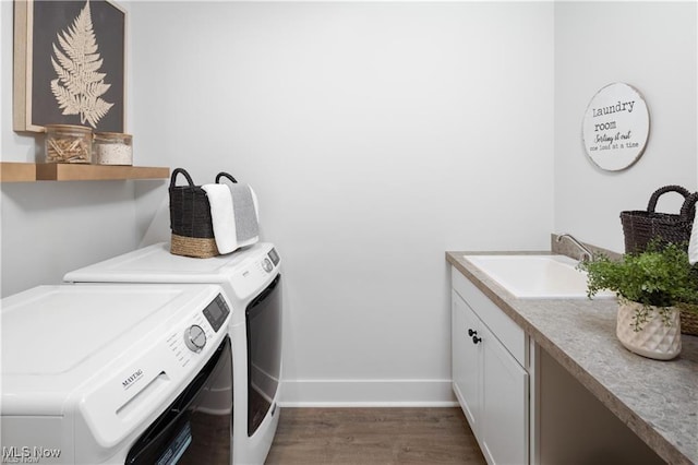 clothes washing area featuring separate washer and dryer, sink, dark hardwood / wood-style flooring, and cabinets