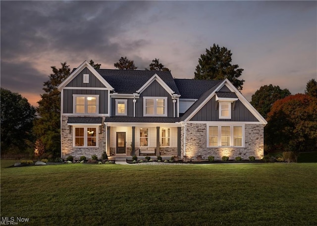 craftsman-style home featuring covered porch and a lawn