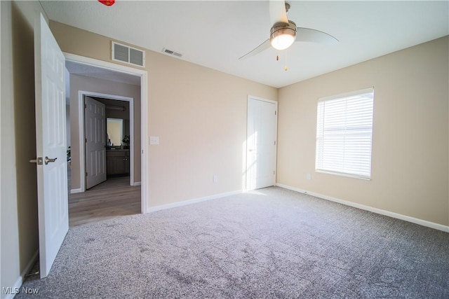 spare room featuring ceiling fan and light carpet