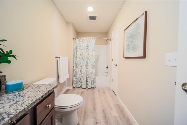 full bathroom with shower / tub combo with curtain, wood-type flooring, toilet, and vanity