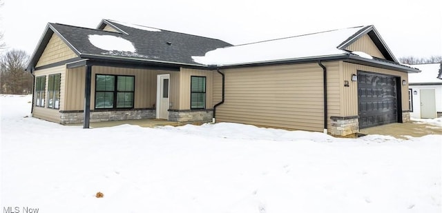 snow covered house with a garage