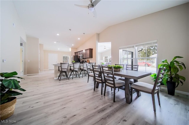 dining space with ceiling fan, lofted ceiling, and light wood-type flooring