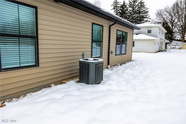 snow covered property with cooling unit