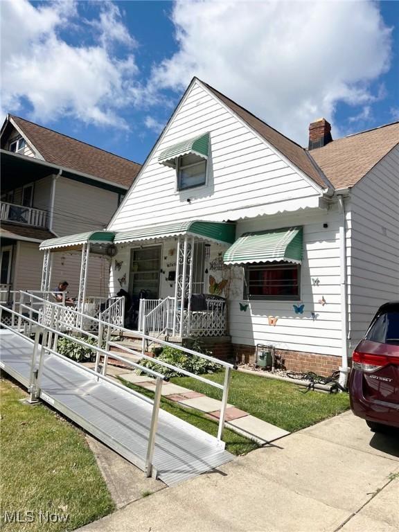 bungalow-style home featuring covered porch and a front lawn