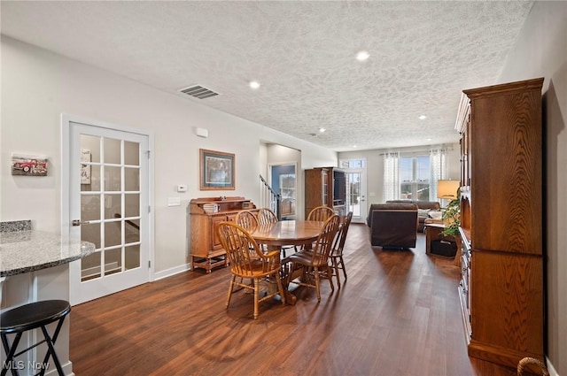 dining room featuring dark hardwood / wood-style floors and a textured ceiling