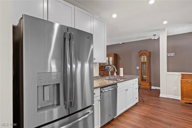 kitchen featuring white cabinetry, sink, dark stone counters, stainless steel appliances, and dark wood-type flooring