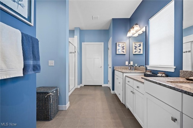 bathroom featuring vanity, a shower with door, and tile patterned flooring