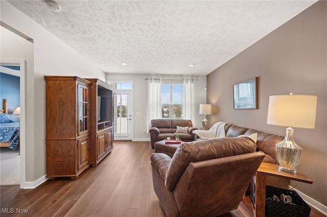 living room with dark hardwood / wood-style floors and a textured ceiling