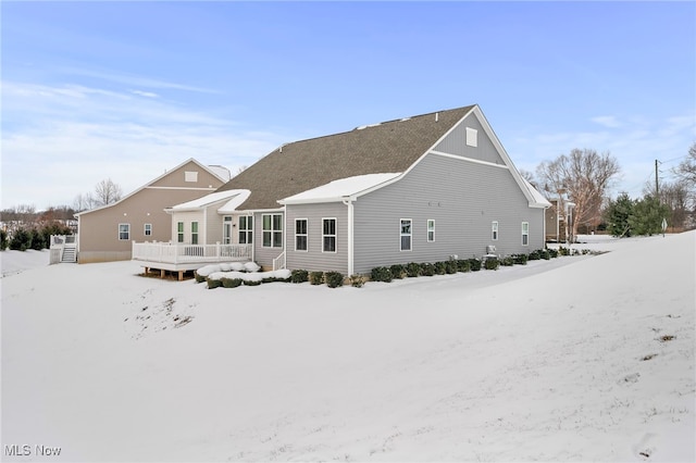 snow covered house with a deck