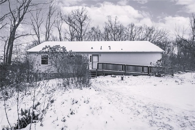 snow covered rear of property featuring a wooden deck