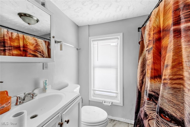 bathroom featuring vanity, toilet, and a textured ceiling