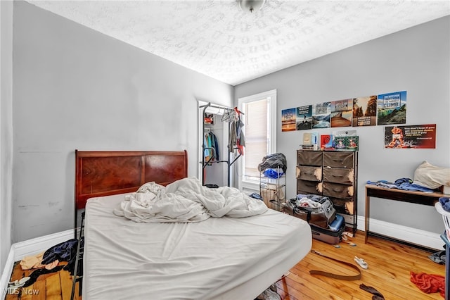 bedroom with hardwood / wood-style floors and a textured ceiling