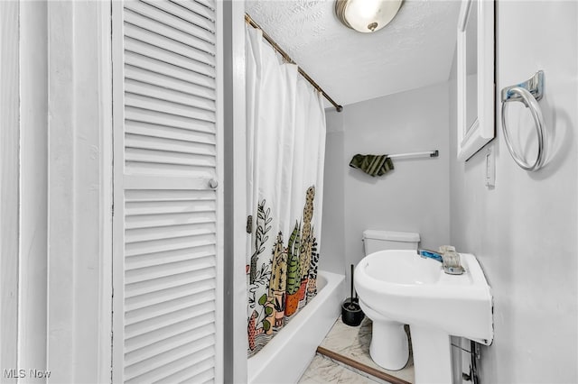 bathroom featuring curtained shower and a textured ceiling