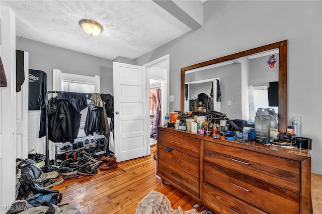 bedroom with light hardwood / wood-style floors, a closet, and a textured ceiling