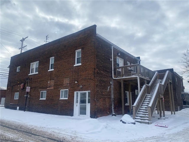 snow covered property with a balcony