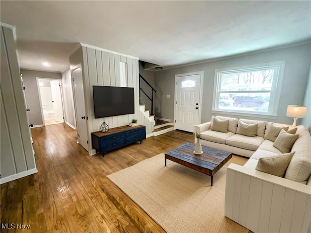 living room featuring crown molding and light wood-type flooring