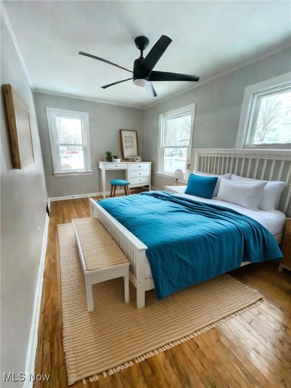 bedroom with multiple windows, ceiling fan, and light hardwood / wood-style flooring