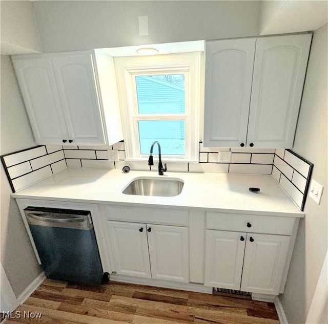 kitchen featuring white cabinets, dark wood-type flooring, sink, and dishwasher