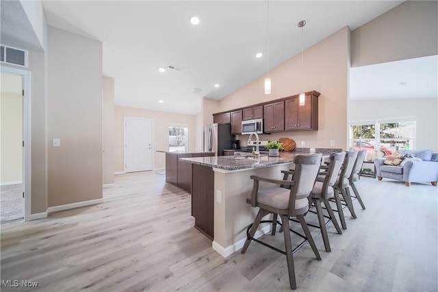 kitchen with pendant lighting, stone counters, a healthy amount of sunlight, and appliances with stainless steel finishes