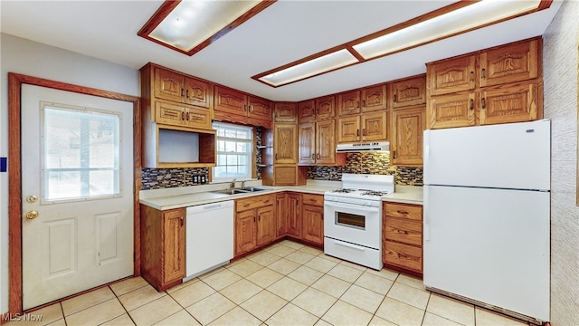 kitchen with sink, a wealth of natural light, white appliances, and decorative backsplash