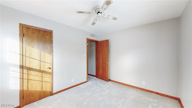 carpeted spare room featuring ceiling fan