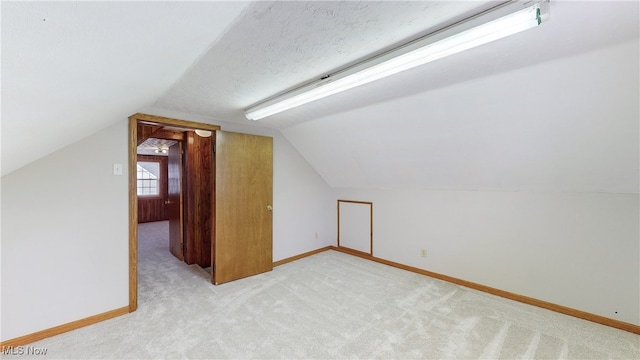 bonus room featuring lofted ceiling and light carpet