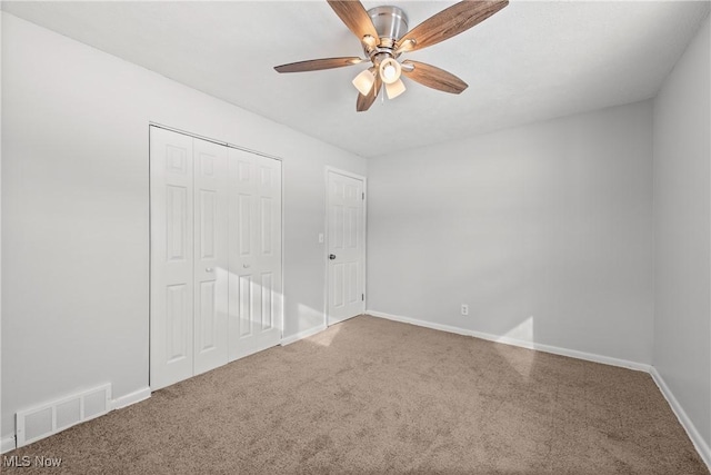 unfurnished bedroom with ceiling fan, carpet, and a closet