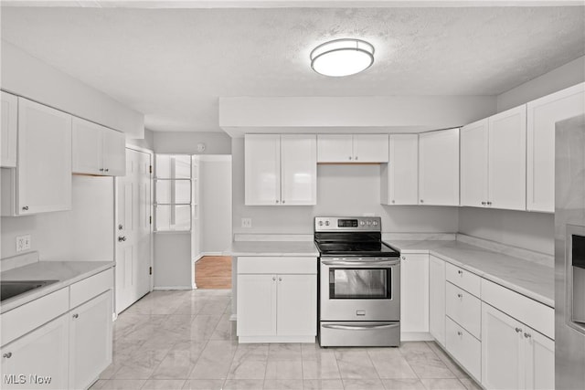 kitchen featuring a textured ceiling, white cabinets, and stainless steel electric range oven