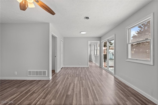 spare room with dark hardwood / wood-style flooring, ceiling fan, and a textured ceiling