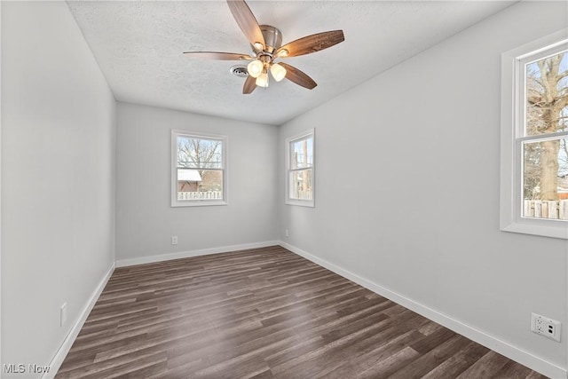 empty room featuring dark wood-type flooring, a textured ceiling, and ceiling fan