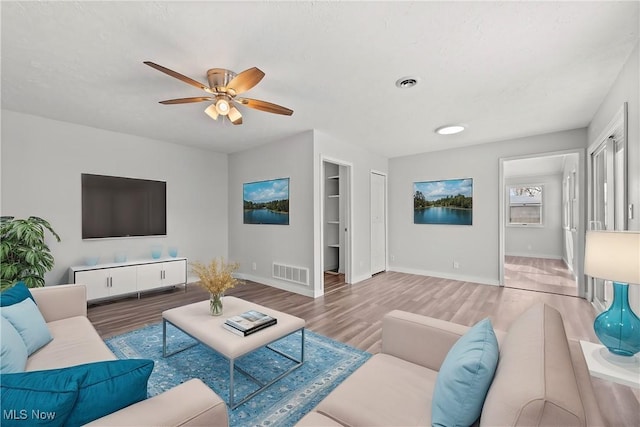 living room featuring hardwood / wood-style flooring and ceiling fan