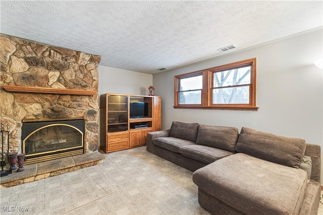 living room with light carpet, a fireplace, and a textured ceiling