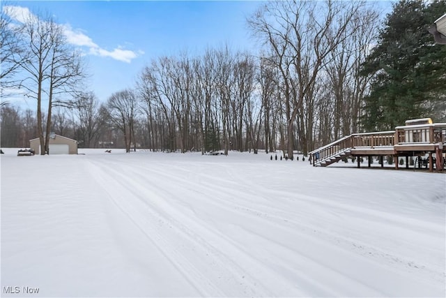 yard covered in snow with a garage and an outdoor structure