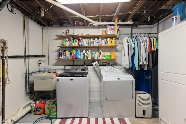 laundry area with separate washer and dryer and sink