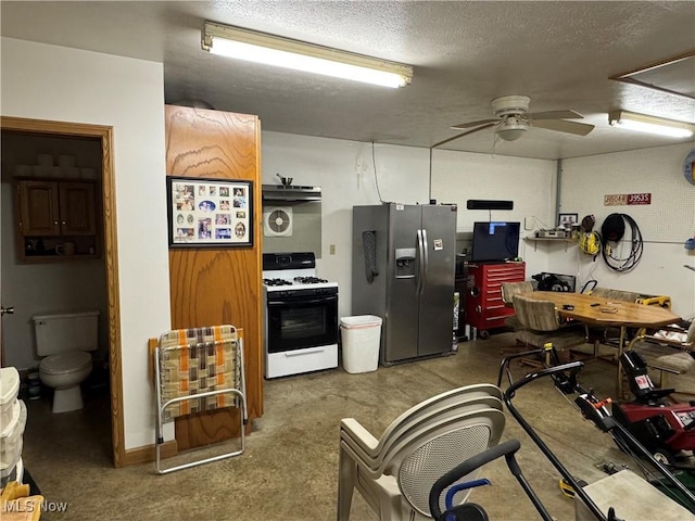 kitchen featuring stainless steel refrigerator with ice dispenser, concrete flooring, a textured ceiling, ceiling fan, and gas range oven