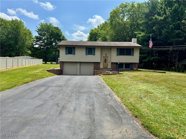 3438 Warren Meadville Rd, Cortland, OH 44410 - split foyer home with a garage, asphalt driveway, brick siding, and a chimney
