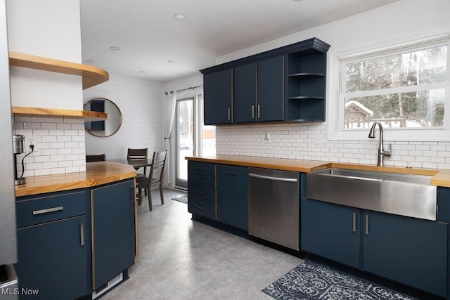 kitchen featuring butcher block countertops, sink, dishwasher, and blue cabinets